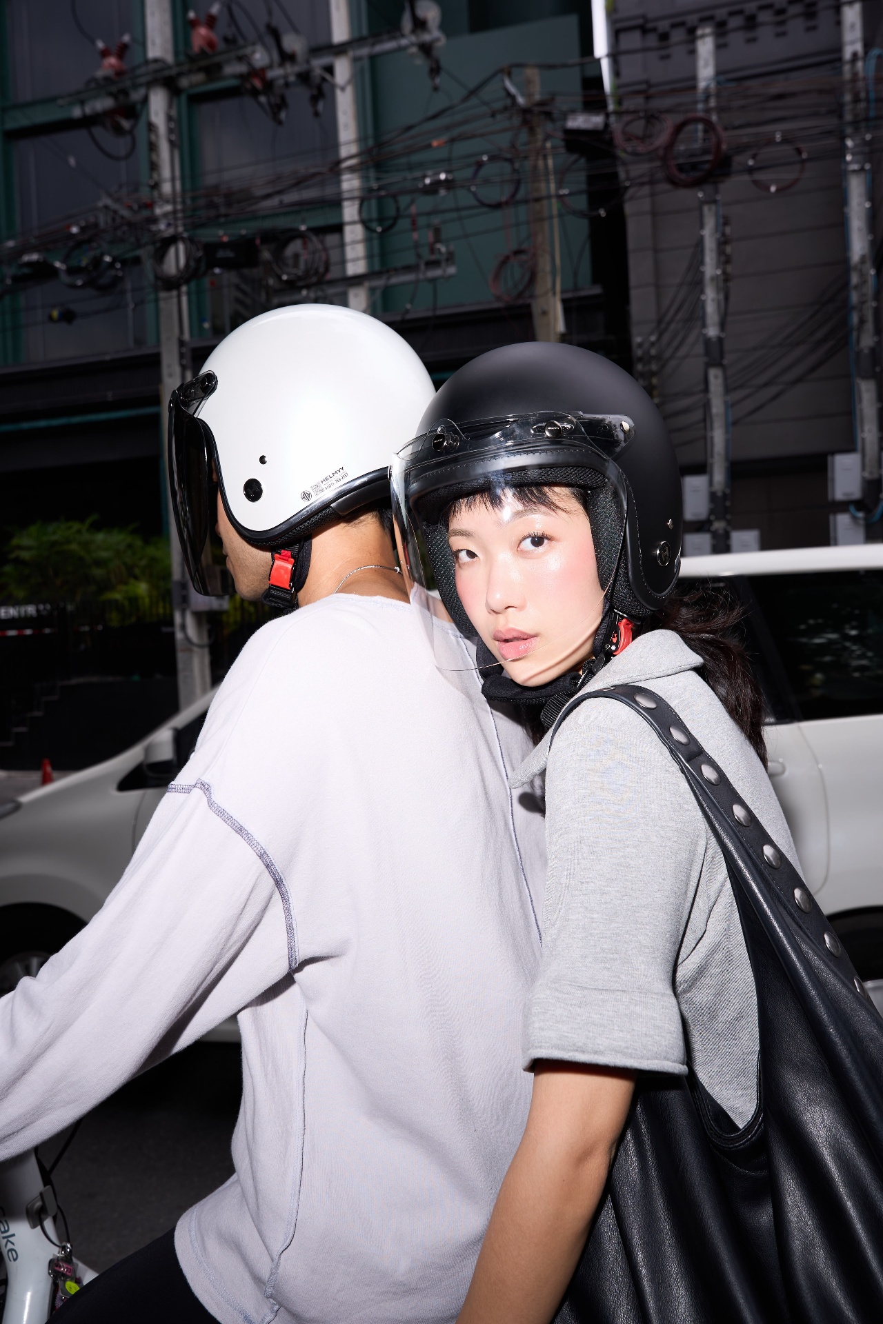 Two riders on a Cake electric bike wearing HELMYY helmets with clear shields