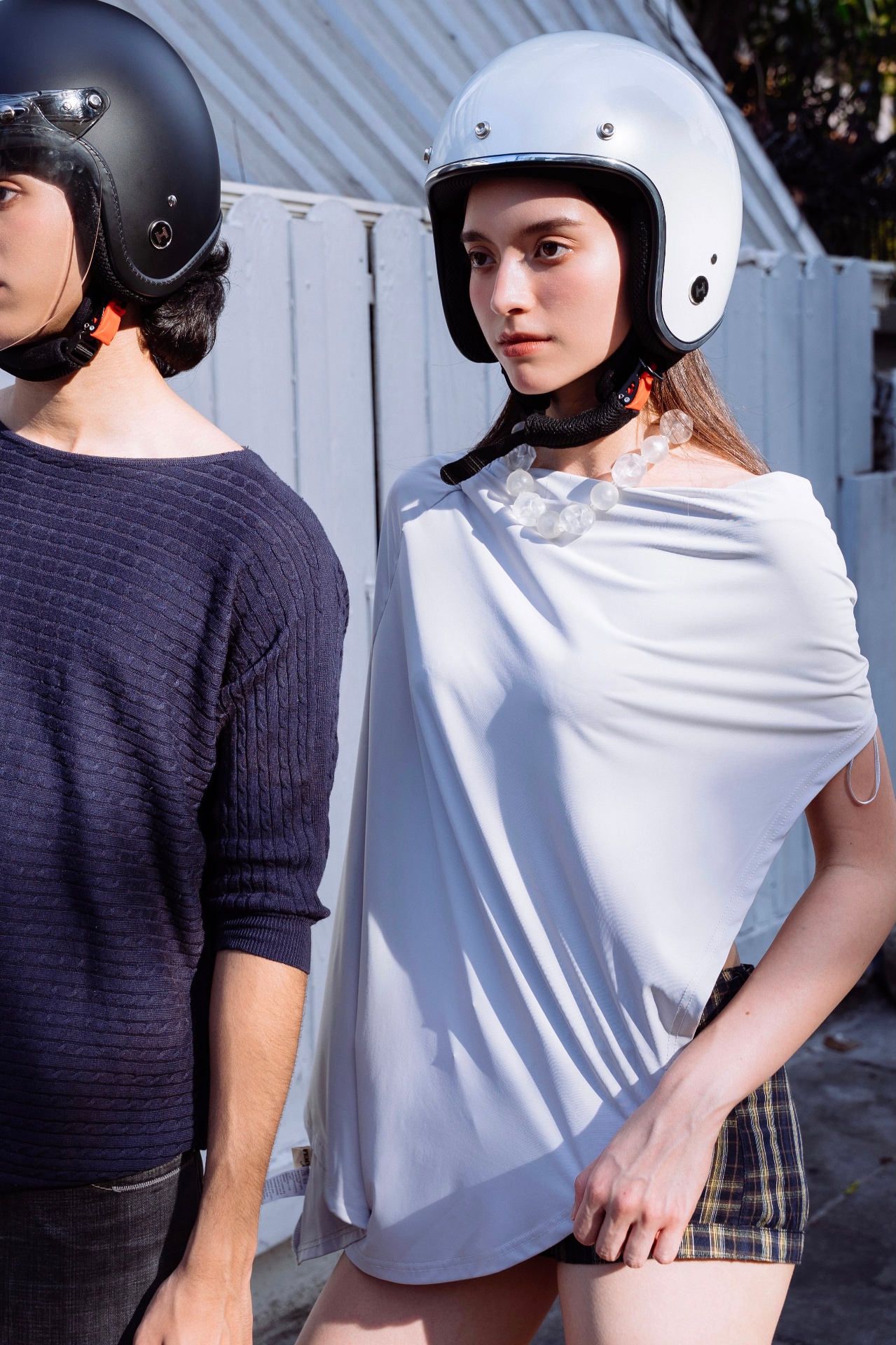 HELMYY Core — matte black and pearl white helmets worn by two models in editorial styling
